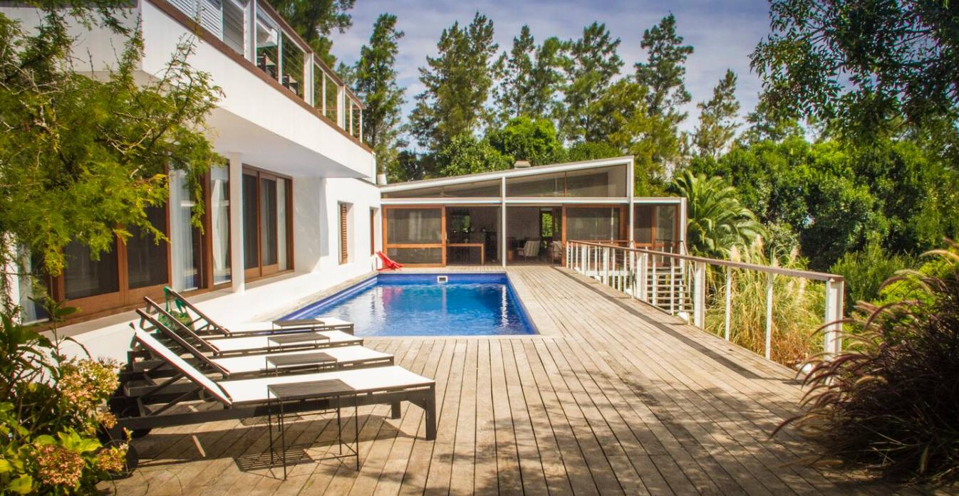 Deck de madera y piscina rodeados de monte